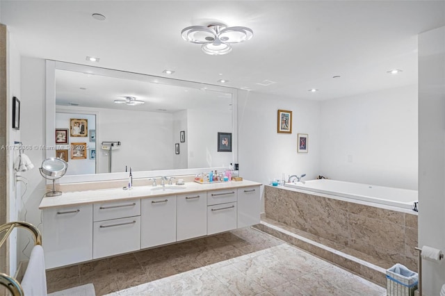 bathroom featuring vanity and tiled bath