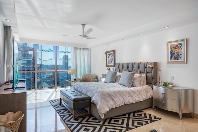 bedroom featuring ceiling fan and a wall of windows