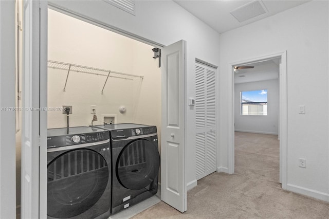 clothes washing area with light carpet and washing machine and clothes dryer