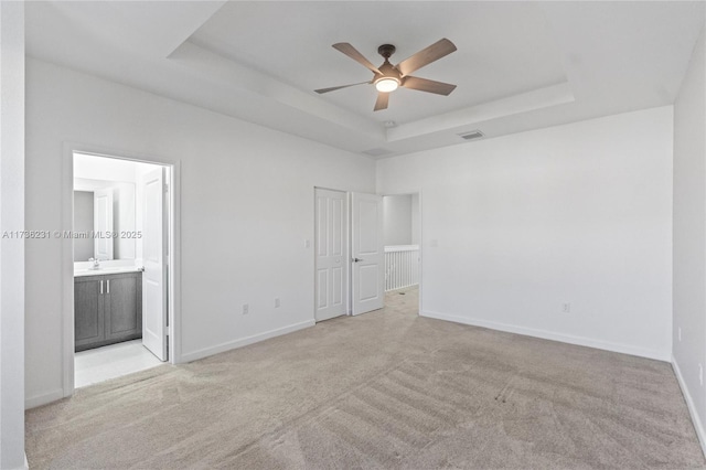 carpeted spare room featuring ceiling fan, a raised ceiling, and sink