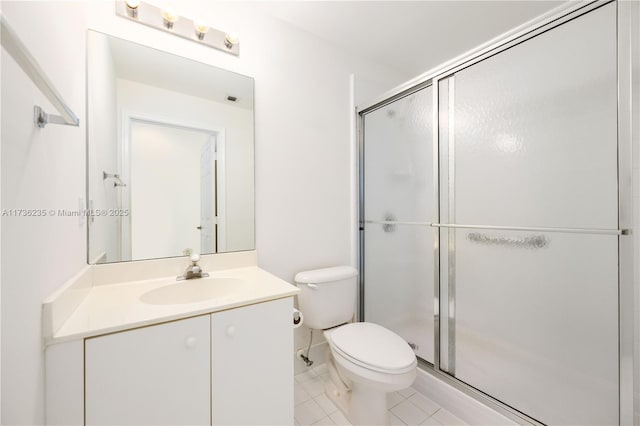 bathroom with a shower with door, vanity, tile patterned flooring, and toilet