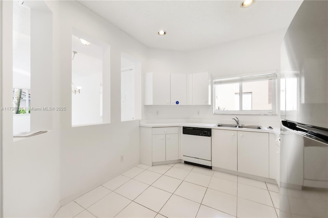 kitchen with stainless steel refrigerator, white cabinetry, white dishwasher, and sink