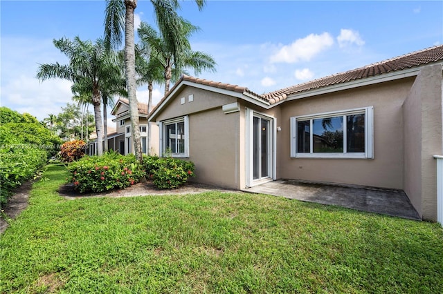 back of property with a patio area and a lawn