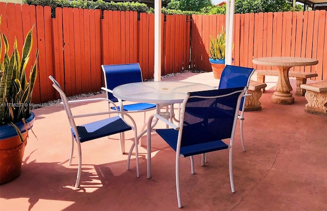 view of patio featuring outdoor dining space and fence