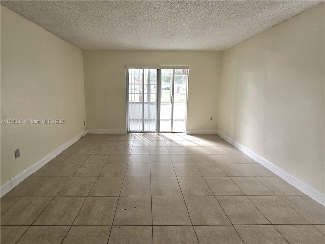 tiled spare room with a textured ceiling