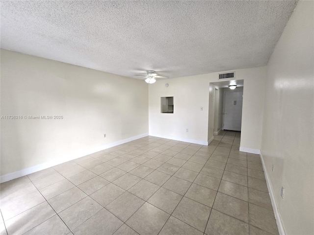 spare room featuring light tile patterned floors, a textured ceiling, and ceiling fan