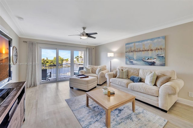 living room featuring ornamental molding, light wood-style flooring, and a ceiling fan