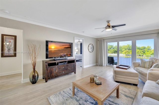 living room featuring ceiling fan, ornamental molding, light wood-style flooring, and baseboards