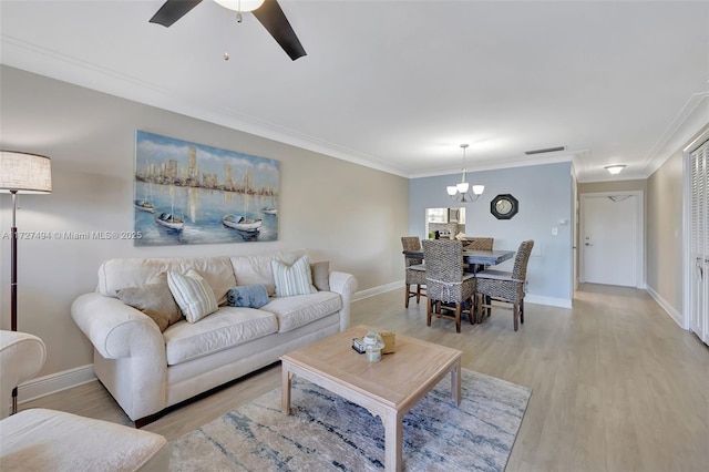 living room with a ceiling fan, light wood-style flooring, ornamental molding, and baseboards