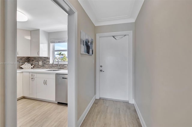 entryway featuring light wood-style floors, baseboards, and a sink