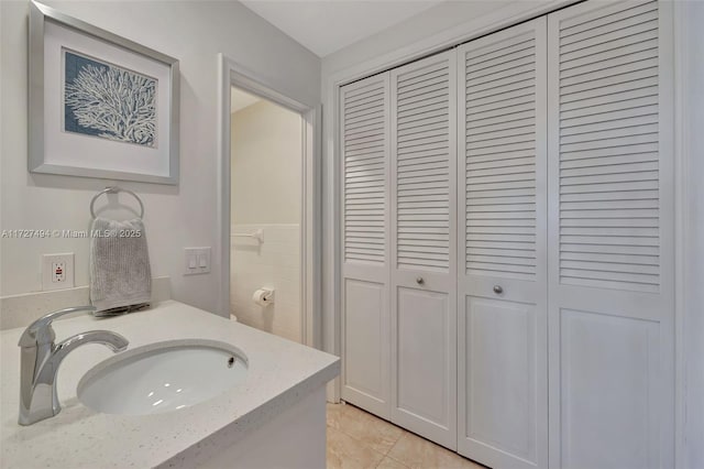 bathroom featuring tile patterned floors, a closet, and vanity