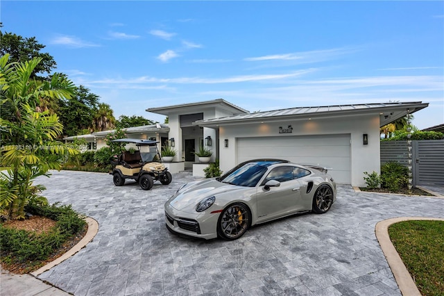 16141 W Troon Cir, Miami Lakes, FL 33014 - view of front of property featuring a standing seam roof, stucco siding, decorative driveway, and a garage