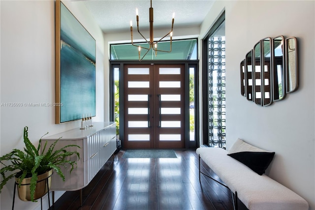 foyer with dark hardwood / wood-style floors, an inviting chandelier, and a textured ceiling