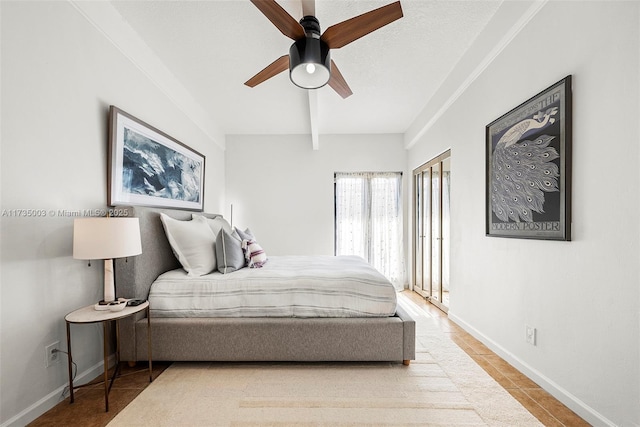 tiled bedroom featuring beamed ceiling, ceiling fan, and a textured ceiling