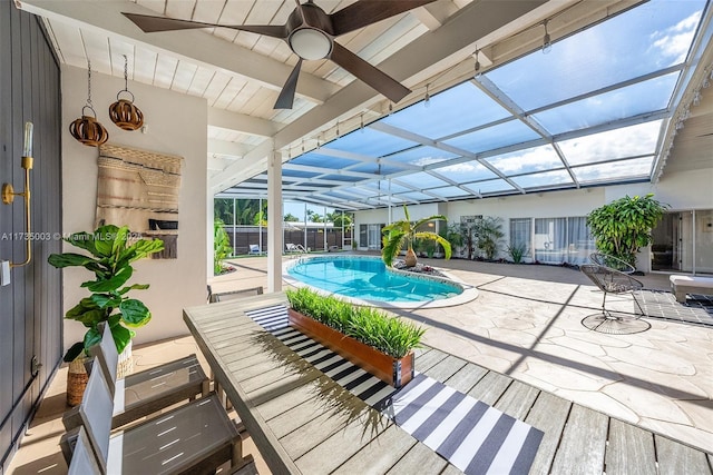 view of pool with a patio, ceiling fan, and glass enclosure