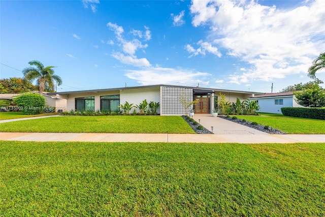 single story home featuring a carport and a front lawn