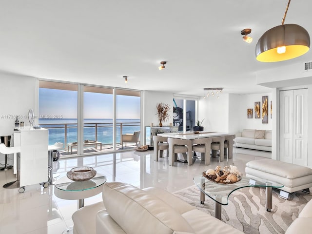 living room featuring a water view, expansive windows, and light tile patterned flooring