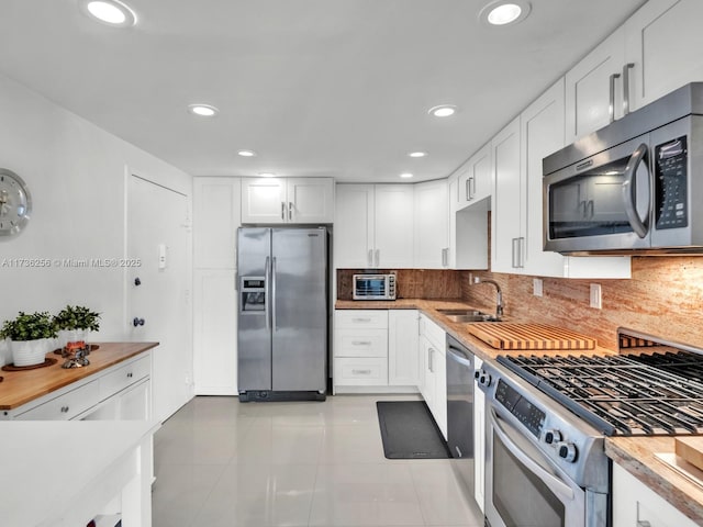 kitchen with white cabinetry, sink, wood counters, and appliances with stainless steel finishes