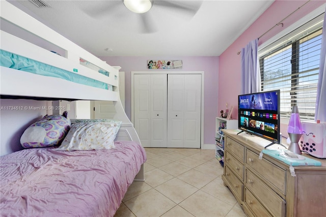 bedroom with ceiling fan, a closet, and light tile patterned floors