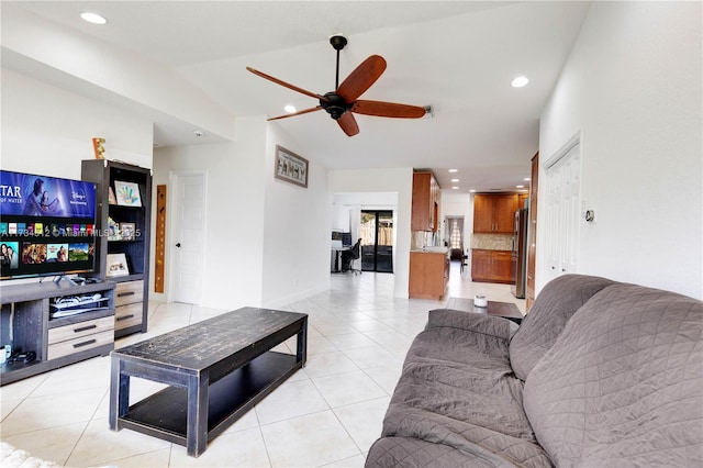 living room featuring lofted ceiling, ceiling fan, and light tile patterned flooring