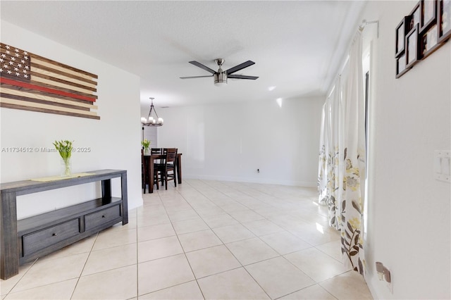 interior space featuring ceiling fan with notable chandelier, a textured ceiling, and light tile patterned flooring