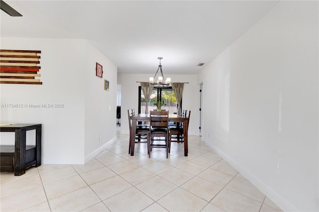 tiled dining room featuring a notable chandelier