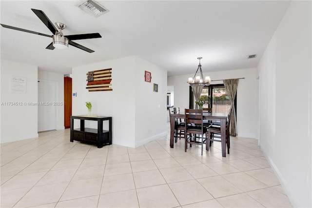 tiled dining space with ceiling fan with notable chandelier