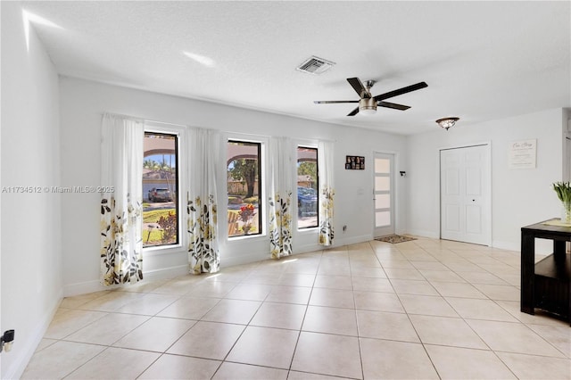 interior space featuring ceiling fan and a textured ceiling