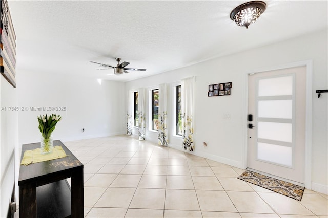 entrance foyer featuring light tile patterned flooring, ceiling fan, and a textured ceiling