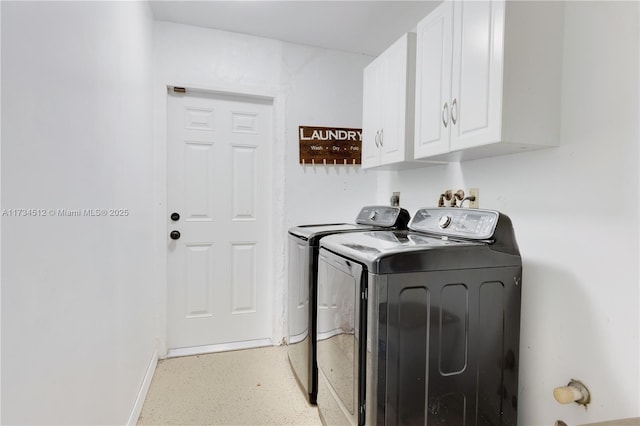 washroom with cabinets and washer and clothes dryer