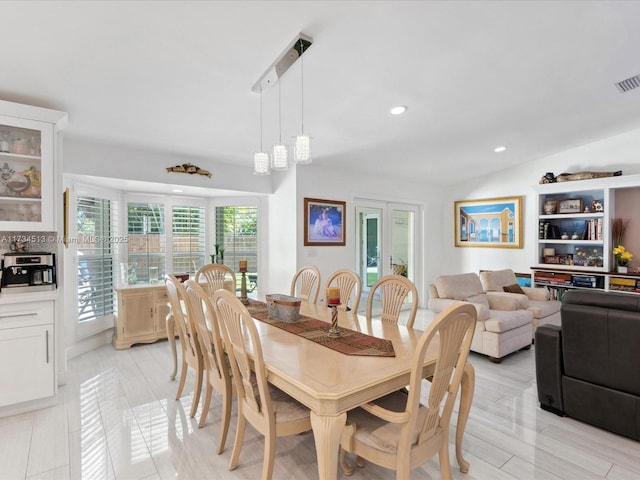 dining area with french doors and vaulted ceiling