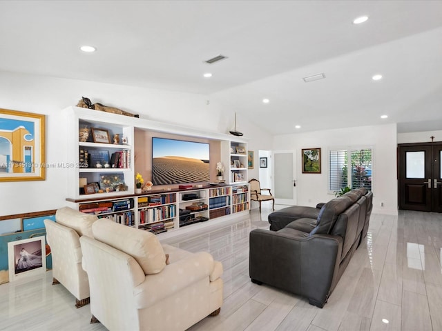 living room featuring lofted ceiling and light hardwood / wood-style floors