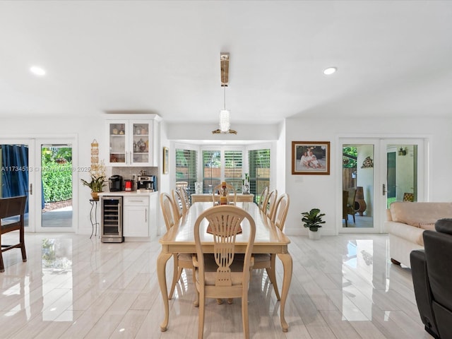 dining room with french doors, a healthy amount of sunlight, and beverage cooler