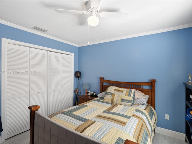 bedroom featuring ornamental molding, ceiling fan, and a closet