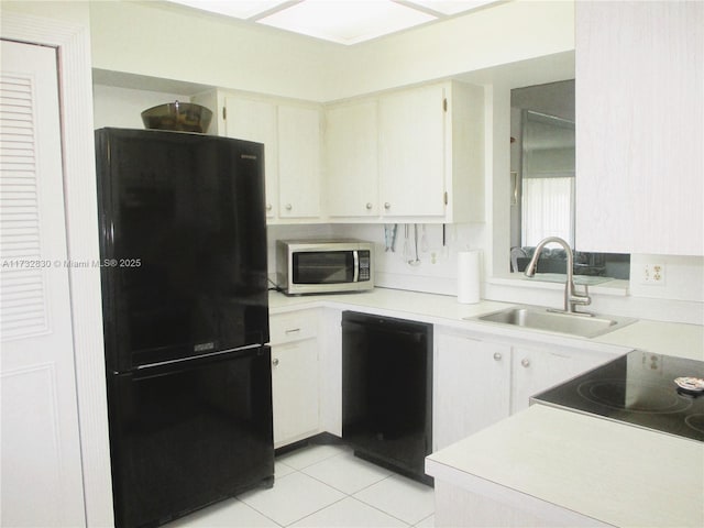 kitchen with white cabinets, light tile patterned floors, sink, and black appliances