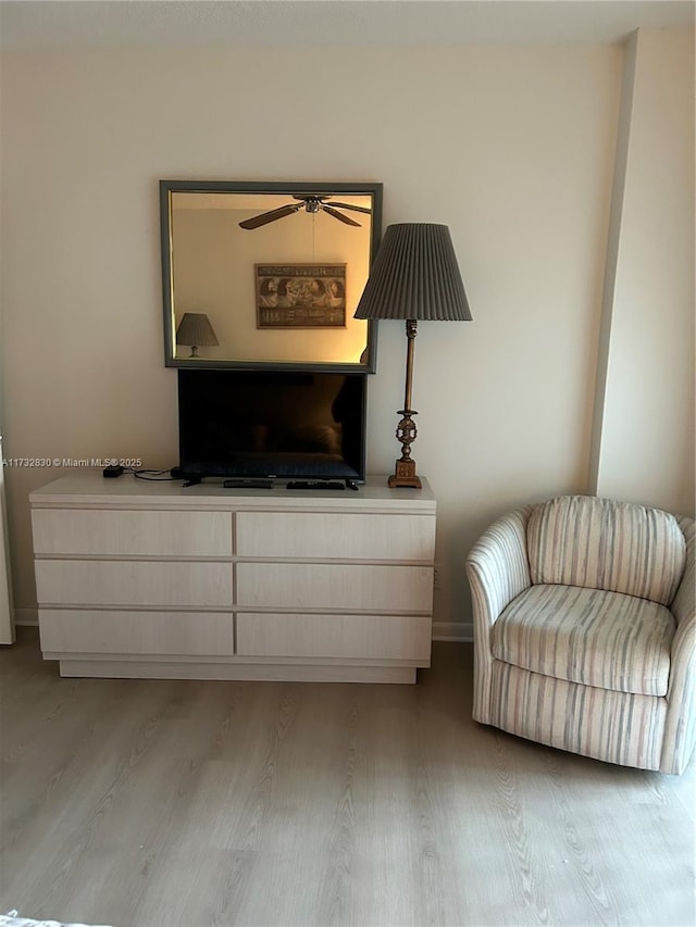 living area with ceiling fan and light hardwood / wood-style flooring