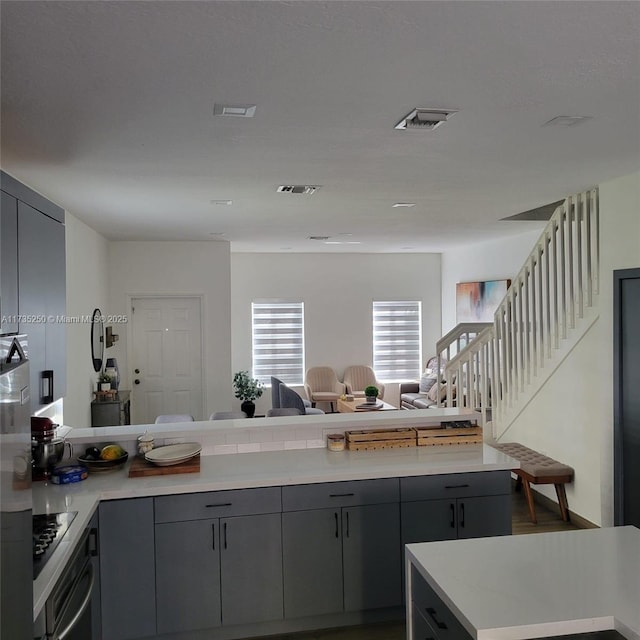 kitchen with wall oven, black electric stovetop, and gray cabinetry