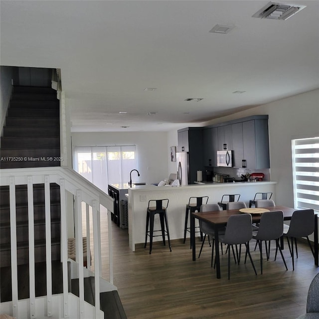 dining area featuring dark hardwood / wood-style flooring, sink, and a healthy amount of sunlight