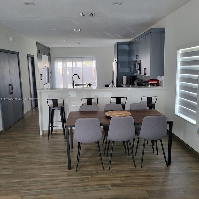 dining area with sink and dark wood-type flooring