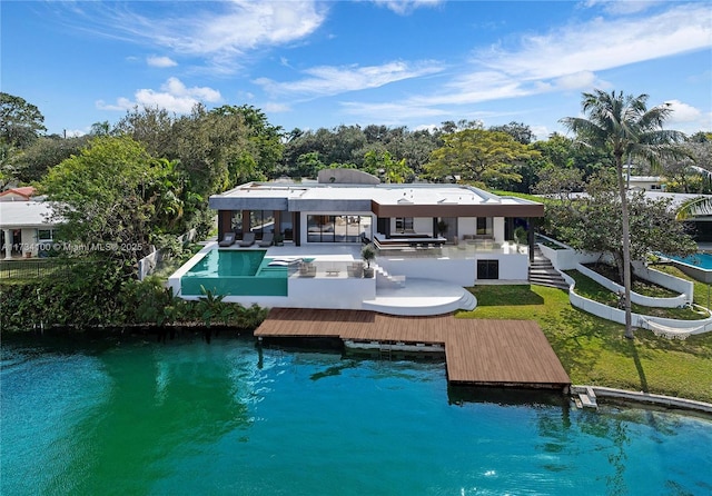 back of property featuring a water view, a pool, and a patio area