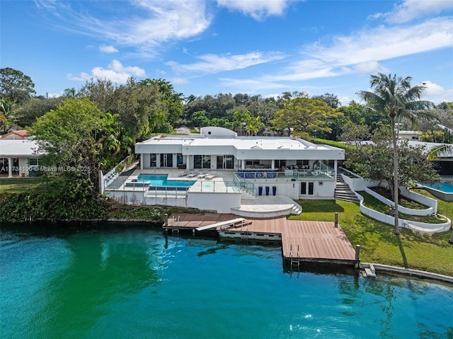 2091 NE 191st Dr, North Miami Beach, FL 33179 - back of property featuring a balcony, an outdoor pool, a water view, a patio area, and a lawn