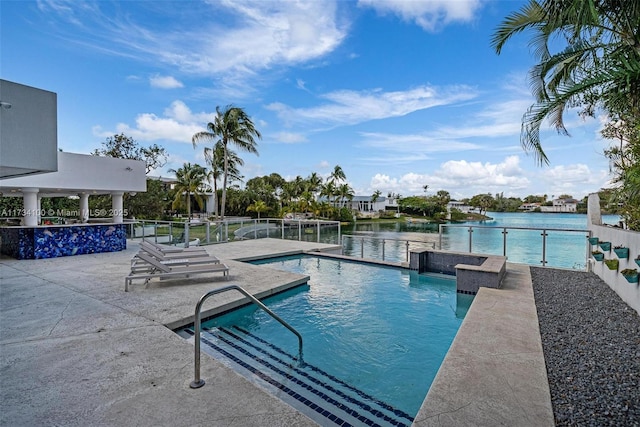 view of swimming pool with a patio, pool water feature, and a water view