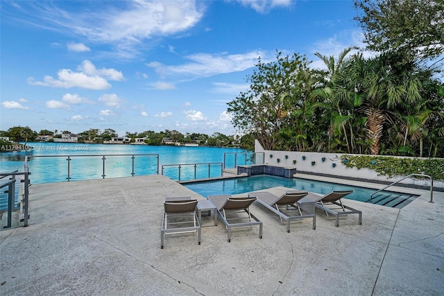 view of pool with a patio and a water view