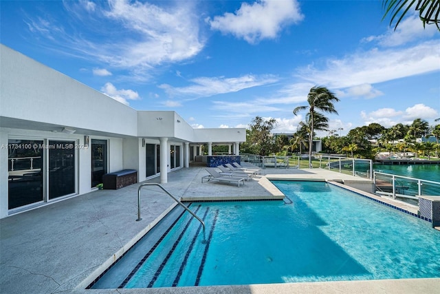 view of swimming pool with a patio and a water view