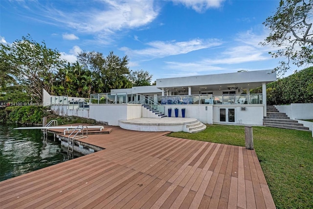 view of dock with a water view and a yard