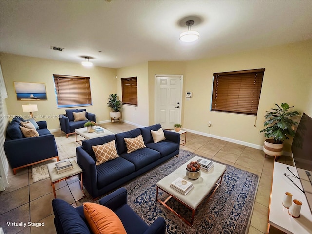 tiled living room with baseboards and visible vents