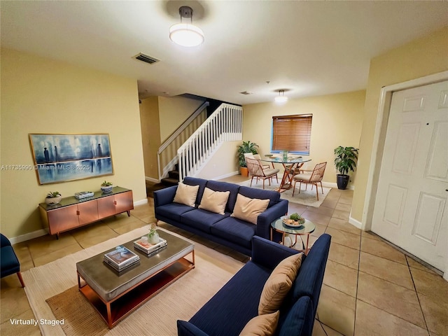 tiled living area featuring visible vents, stairs, and baseboards
