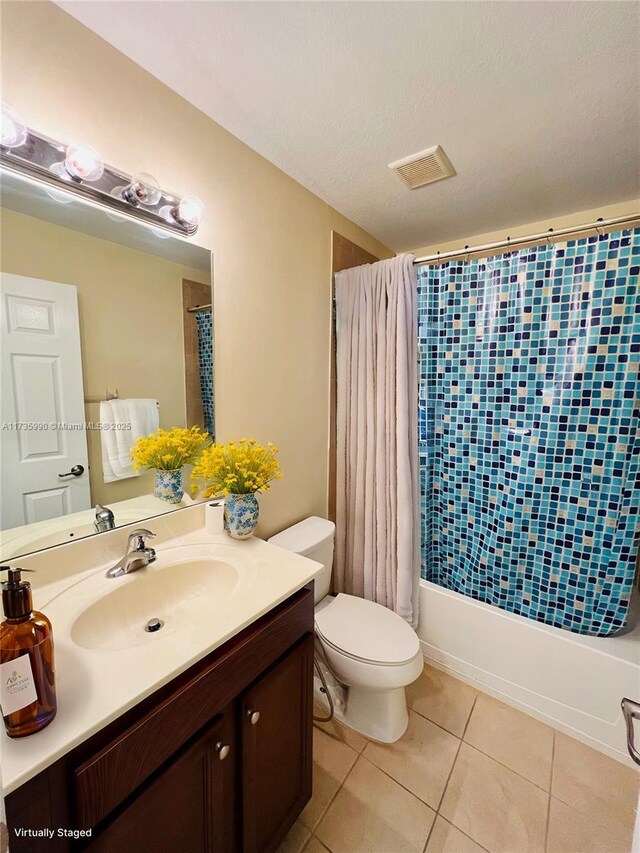 bathroom with visible vents, shower / tub combo, tile patterned floors, vanity, and toilet