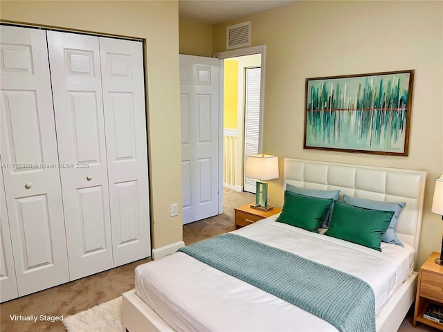 carpeted bedroom with baseboards, visible vents, and a closet