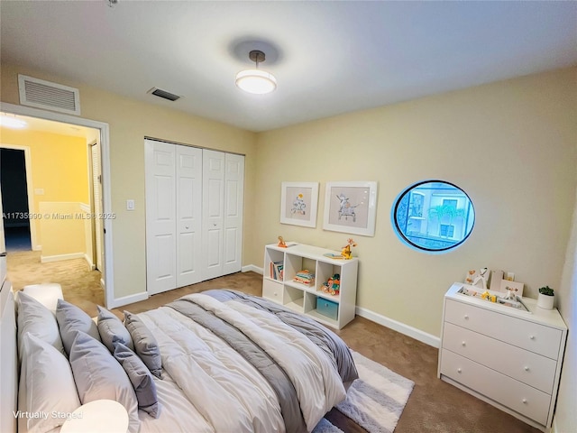 bedroom with carpet flooring, baseboards, visible vents, and a closet